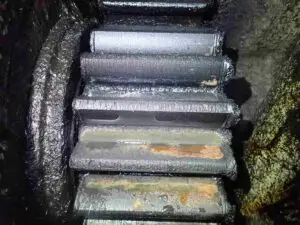 Softer gear tooth showing plastic deformation and polishing wear, commonly used in winch applications.